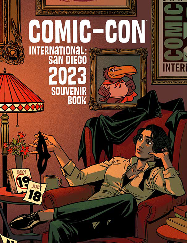 The cover of the 2023 Souvenir Book features the art of Becky Cloonan. The cover depicts a seemingly relaxed setting as the superhero takes time from their day to reflect and look forward to Comic-Con. Their fandom is on display as the iconic logo and Toucan mascot are hung proudly on the walls of their sanctuary.